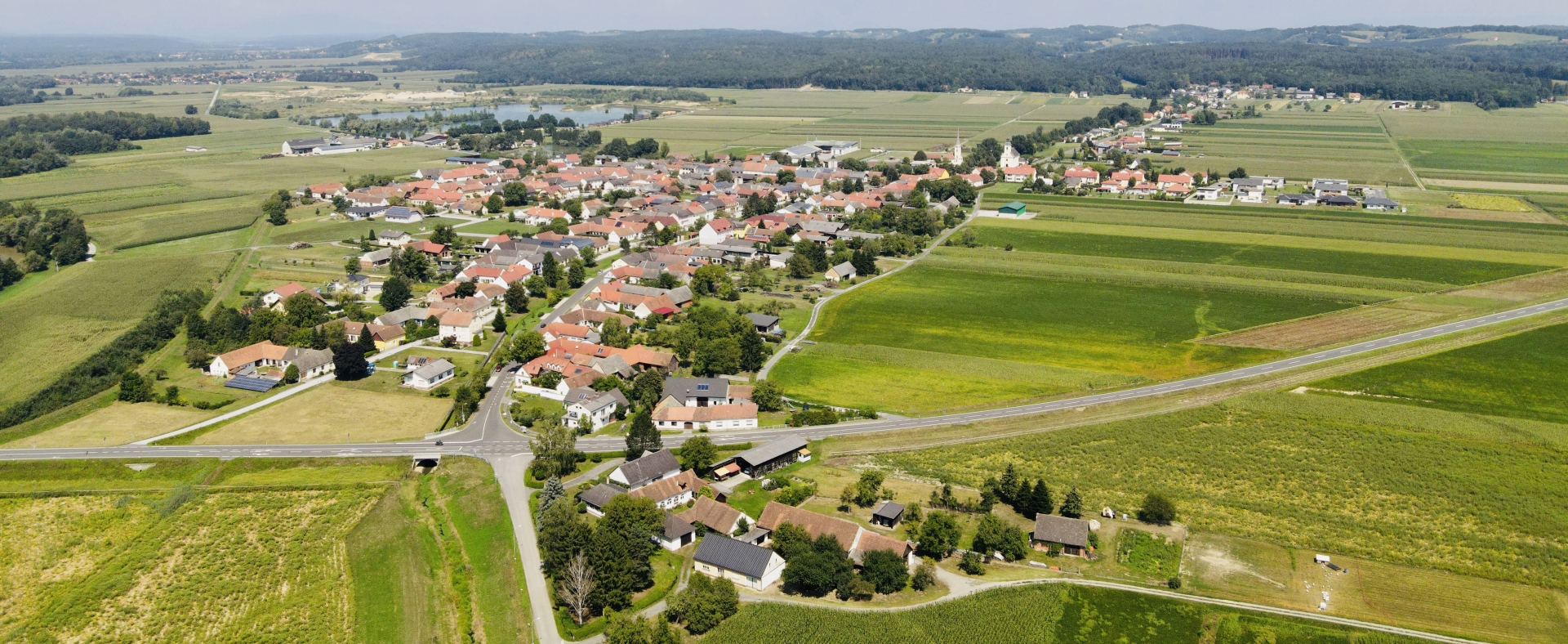 in einer abwechslungsreichen Landschaft mit Wiesen, Feldern und bewaldeten Hügeln