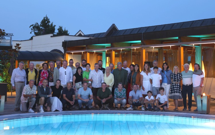 Große Gruppe von Gästen posiert am Pool eines Hotels in Österreich