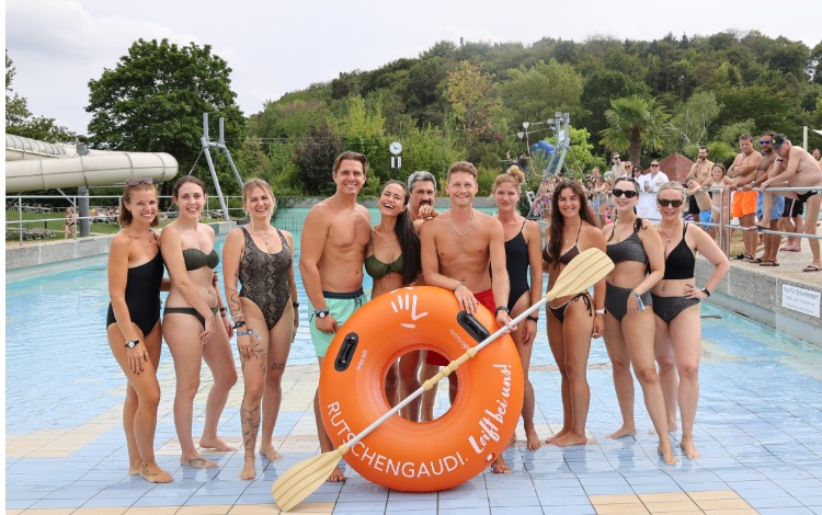 Rutschgaudi-Team mit Schwimmring und Paddel im Freibad