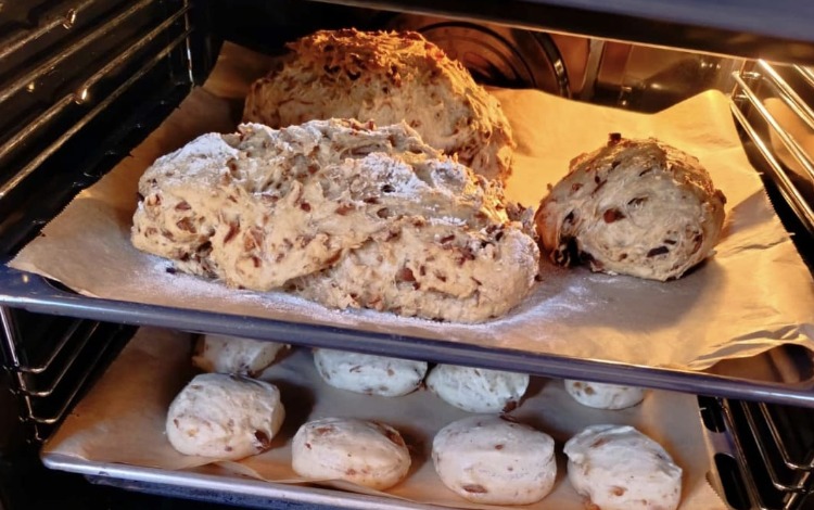 Brotlaibe mit Saaten und Nüssen im Backrohr auf Backpapier
