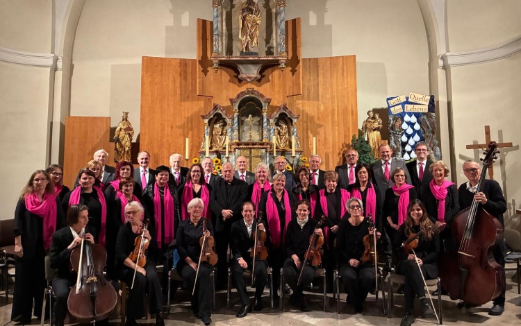 Chor und Musiker mit Instrumenten vor Altar in Kirche mit Spruch "Gott Quelle des Lebens"